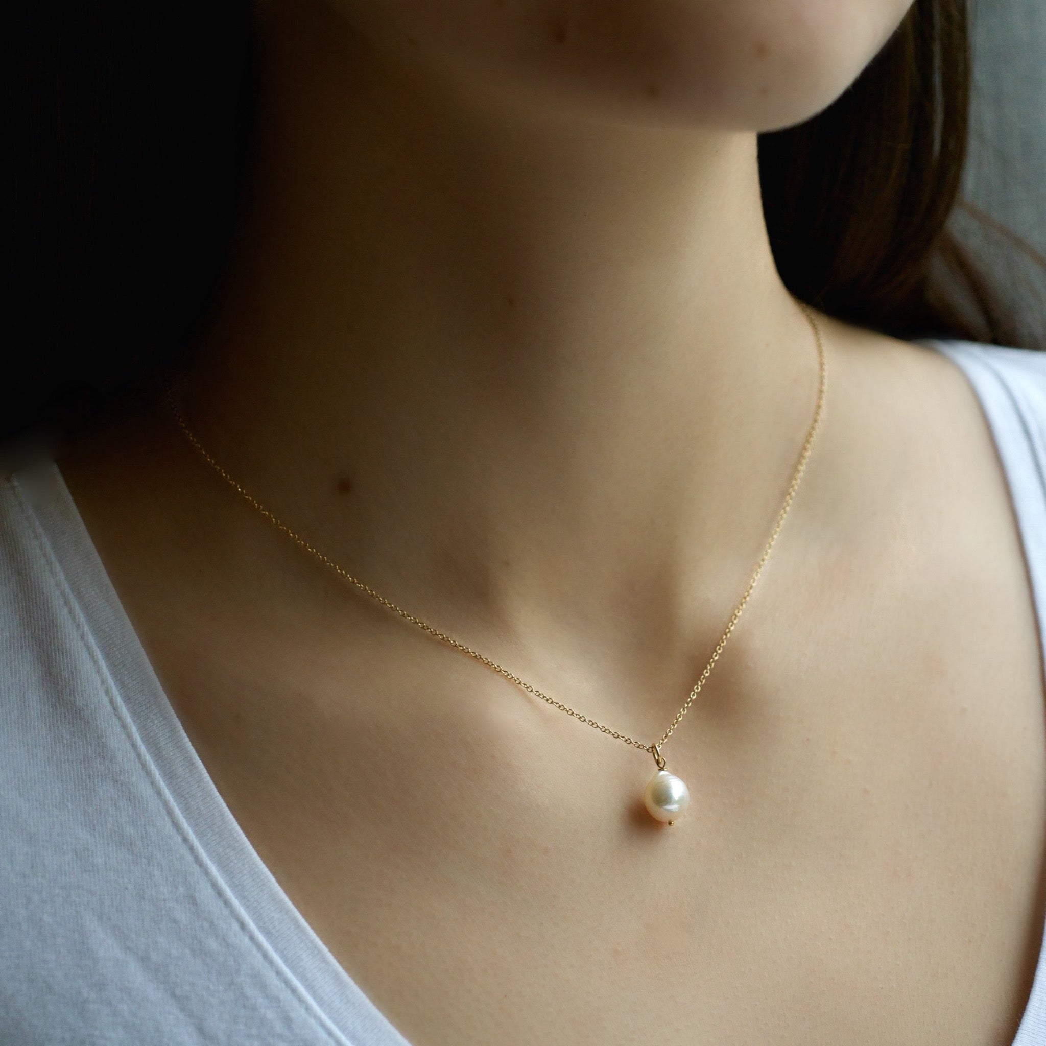 Small Akoya white pearl hanging from a 16 inch 18 karat gold chain